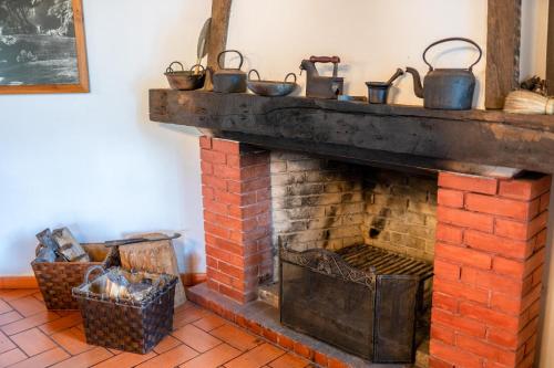 a brick fireplace with pots on top of it at Casa da Tia Clementina in Santana