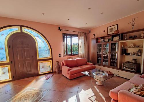 a living room with a red couch and a large door at Villa Sargheruoli in Monteroni di Lecce