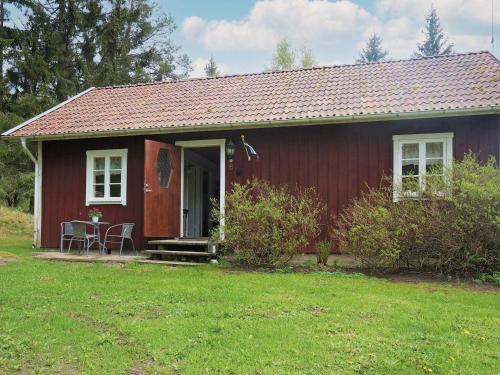 a red house with a table and chairs in front of it at 6 person holiday home in ÅSARP-By Traum in Åsarp