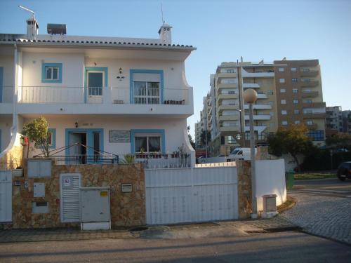 a white house with a fence and some buildings at Casa Afonso in Lagos