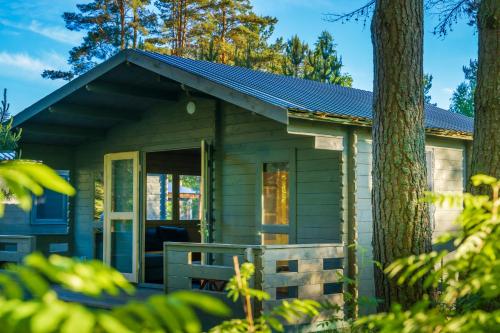 a green tiny house with a porch at Metsaääre Accommodation in Uulu