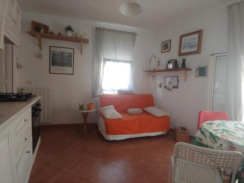 a living room with an orange chair and a window at Casa RoSiLù in Monopoli