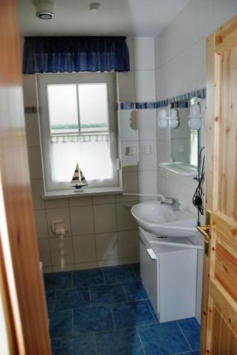 a bathroom with a sink and a toilet and a window at "Tau Hus" im "Roden Hus" in Timmendorf