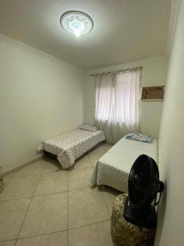 a room with two beds and a window at Praia do Forte - Cabo Frio Edificio Guanabara in Cabo Frio