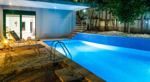 une piscine bleue avec un banc à côté d'une maison dans l'établissement The H Experience - The Blue Lounge with Swimming pool, à Pórto Ráfti