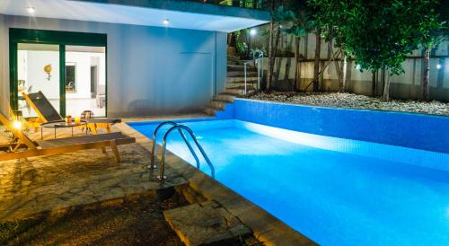 a blue swimming pool with a bench next to a house at The H Experience - The Blue Lounge with Swimming pool in Porto Rafti