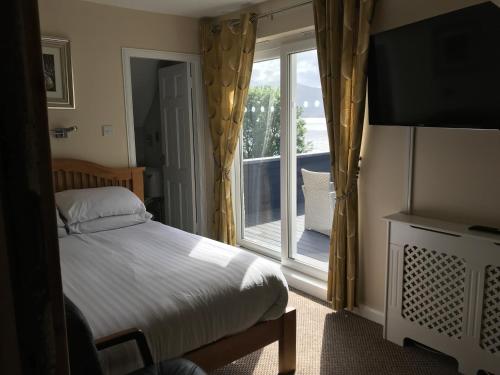 a bedroom with a bed and a large window at Campfield House in Fort William