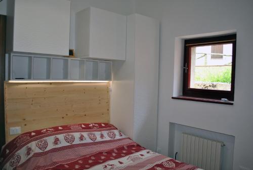 a bedroom with a bed and a window at La casetta di Viola in Abetone