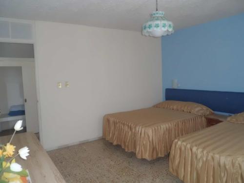 a bedroom with two beds and a chandelier at Suites Angelopolis in Acapulco