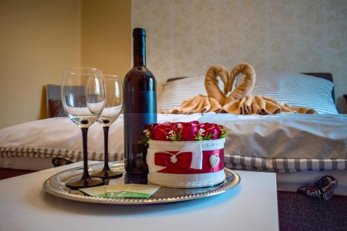 een tafel met een fles wijn en wijnglazen bij LUX Apartman Maroslele in Maroslele
