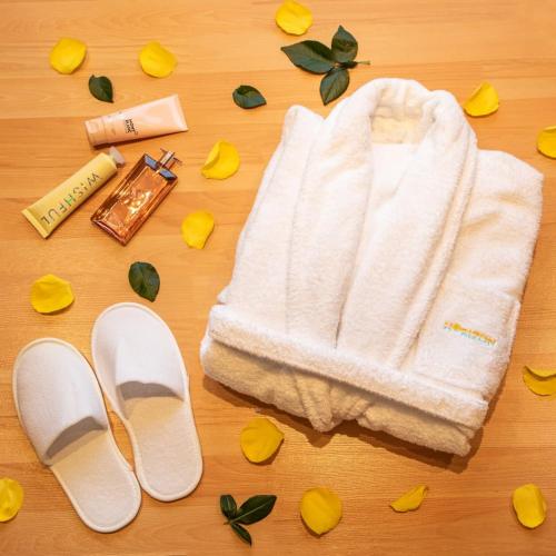 a white towel and a pair of shoes and flowers at Horizon Hotel in Al Başrah
