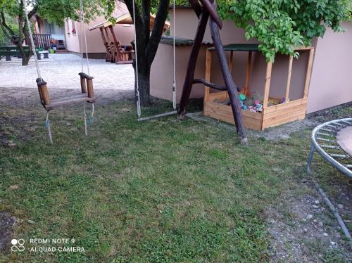 a swing in a yard next to a house at Sárgapart Holiday Home in Poroszló