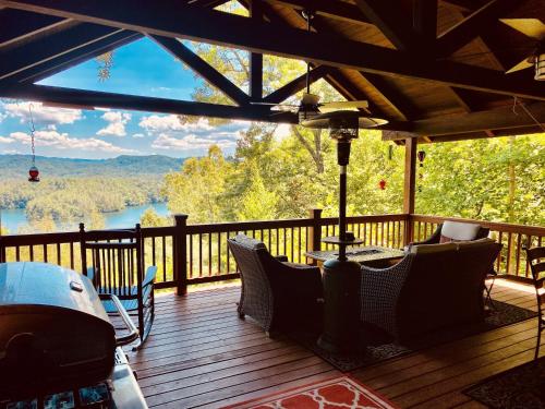 a deck with chairs and a view of a lake at Bear's Mountaintop Home with Gorgeous Lake Views chalet in Santeetlah