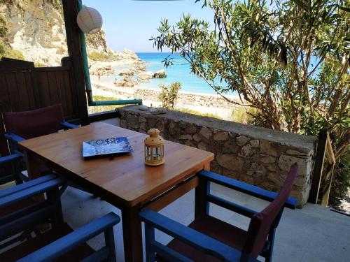 a wooden table and chairs with a view of the ocean at Fetsis Apartments in Agios Nikitas