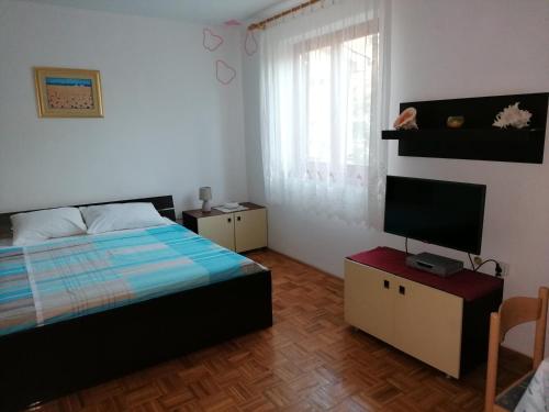Schlafzimmer mit einem Bett und einem Flachbild-TV in der Unterkunft Apartments Maria in Pula