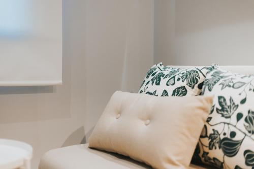 a white couch with a pillow and two pillows at Apartamentos MK77 León - Palomera in León