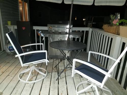 two chairs and a table on a porch with a grill at Hampton House in Clinton