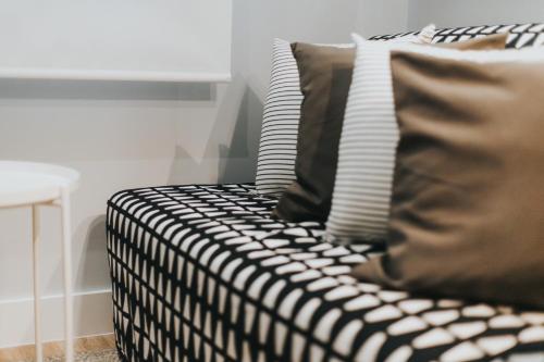 a black and white couch with pillows in a room at Apartamentos MK77 León - Palomera in León