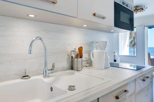 une cuisine avec un évier et un plan de travail dans l'établissement IMMOGROOM - 3 Sea view Panoramic terrace - 1 min beach - CONGRESSBEACH, à Cannes