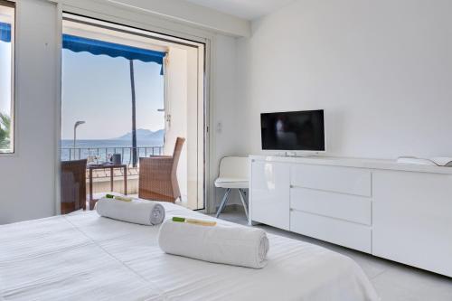カンヌにあるIMMOGROOM - 3 Sea view Panoramic terrace - 1 min beach - CONGRESSBEACHの白いベッドルーム(テレビ付)、ベッド1台(枕2つ付)