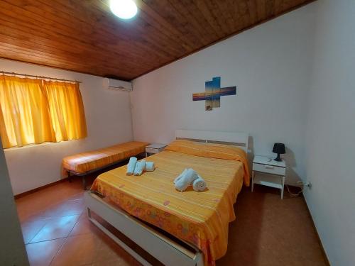 um quarto com 2 camas e um tecto de madeira em Capo summer em Capo Vaticano