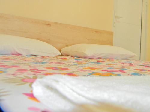 a bed with a colorful comforter and two pillows at Sorella in Kostol