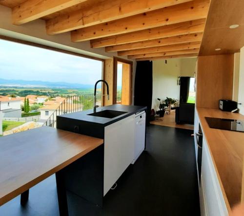 une cuisine avec un évier et une grande fenêtre dans l'établissement élégante villa neuve d'architecte, à Dallet