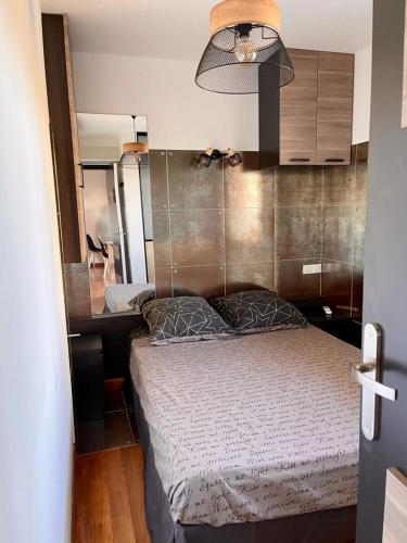 une petite chambre avec un lit et un bureau dans l'établissement Juan les Pins Joli T2 parking inclus!, à Antibes