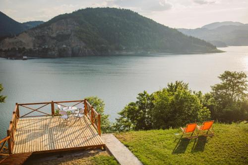 two orange chairs sitting next to a body of water at Zoranovi konaci in Jevtići