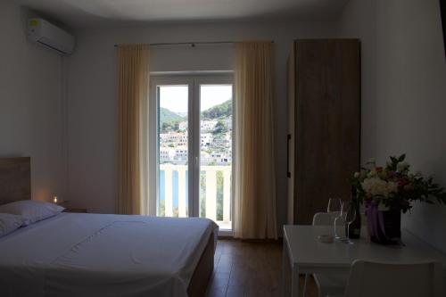a bedroom with a bed and a table and a window at Apartmani Bauk in Pučišća