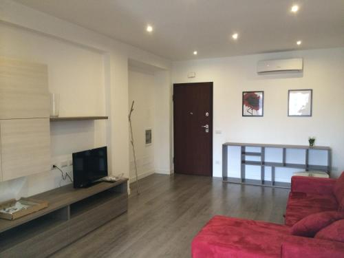 ein Wohnzimmer mit einem roten Sofa und einem TV in der Unterkunft Casa Alessandra in Cassibile