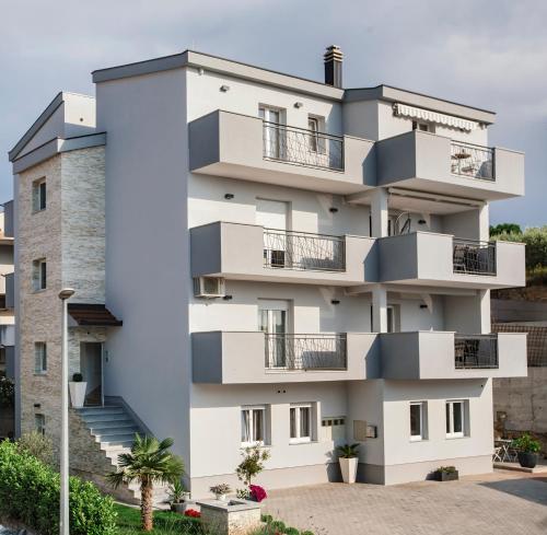 um edifício de apartamentos com varandas e escadas em Apartments Kolovrat em Podstrana