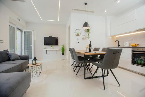 uma cozinha e sala de estar com mesa e cadeiras em Apartments Kolovrat em Podstrana
