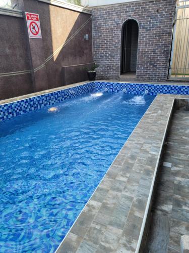 a swimming pool with blue tiles in a building at Camas Hotel & Suite Asero Abeokuta in Abeokuta