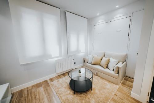 a living room with a couch and a table at Apartamentos MK77 León - Palomera in León