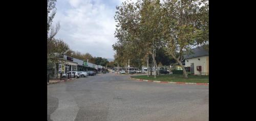 an empty street in a town with cars parked at אירוח אריאל in Hagoshrim