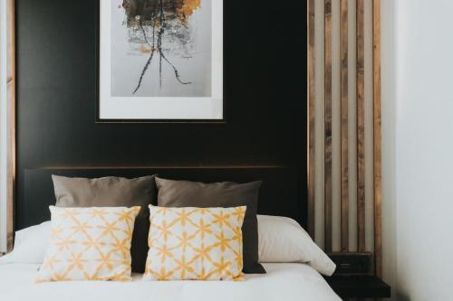 a bedroom with a bed with pillows and a picture at Apartamentos MK77 León - Palomera in León