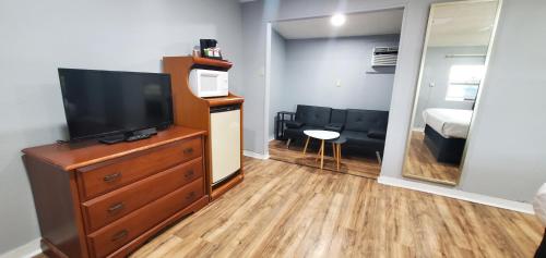 a living room with a television and a dresser with a mirror at Travelers Inn in Flagstaff