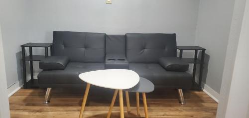 a black couch with a white table and a stool at Travelers Inn in Flagstaff