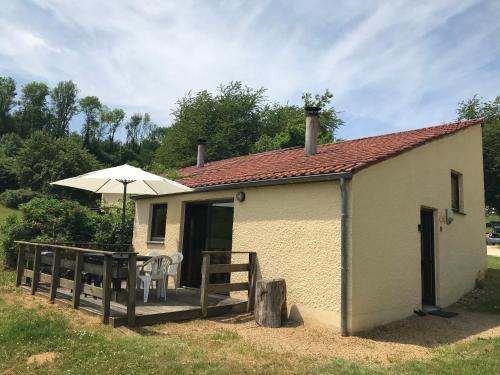 a small building with an umbrella and a deck at Le repaire des hérissons Vallée de Rabais in Virton
