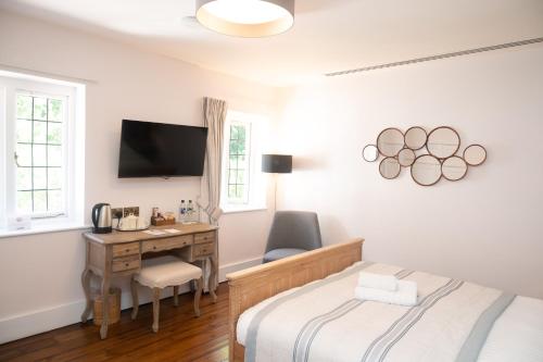 a bedroom with a bed and a desk with a computer at The Olde Bell, BW Signature Collection in Marlow
