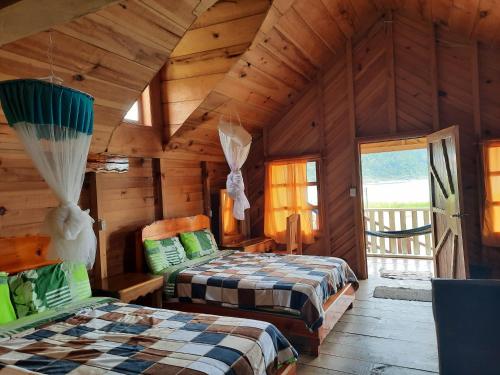 1 dormitorio con 2 camas en una cabaña de madera en Cabañas Islas de Tziscao, en Santiago