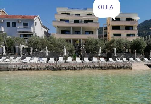 a view of a beach with chairs and a building at Olea in Tivat