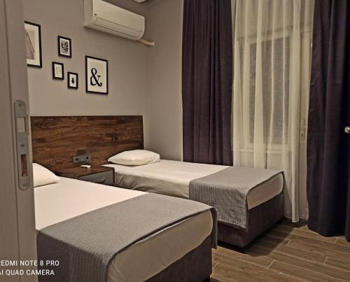 een hotelkamer met 2 bedden en een raam bij Merve Apart Hotel in Alanya