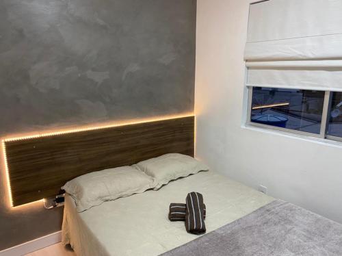 a small bedroom with a bed with a window at LINDO APARTAMENTO 1822 in Balneário Camboriú