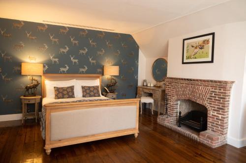 a bedroom with a bed and a fireplace at The Olde Bell, BW Signature Collection in Marlow