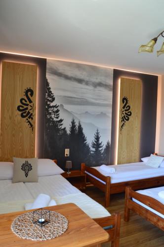 a room with two beds and a painting on the wall at Pokoje Goscinne Pieninska Parzenica in Mizerna
