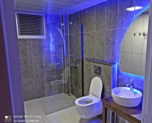 uma casa de banho com um chuveiro, um WC e um lavatório. em Merve Apart Hotel em Alanya