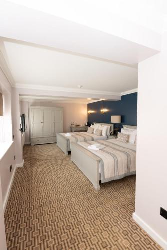 two beds in a large room with blue walls at The Olde Bell, BW Signature Collection in Marlow