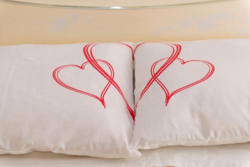 two pillows with hearts painted on them on a bed at Apartments Lovrić in Vodice